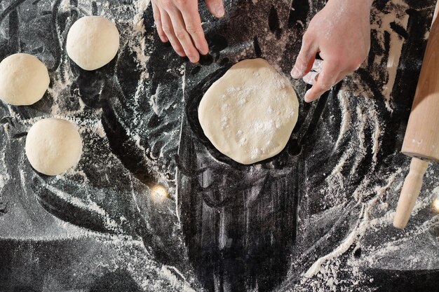 Foto pizzaiolo prepara pizza en la cocina el chef prepara la masa