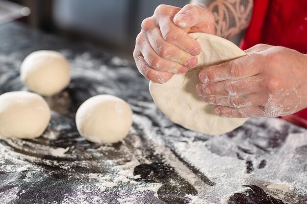 Foto pizzaiolo prepara pizza na cozinha o chef prepara a massa