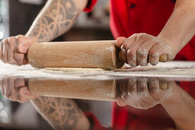 Pizzaiolo prepara pizza na cozinha o chef prepara a massa