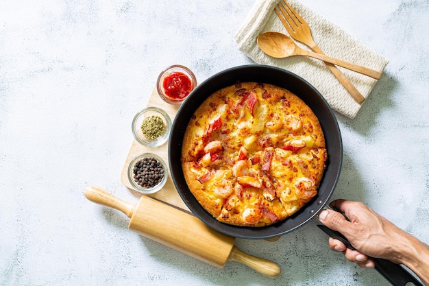 PizzaKöstliche Pizza mit Würstchen auf grauem HintergrundChef verteilt Tomatenmark auf Pizza