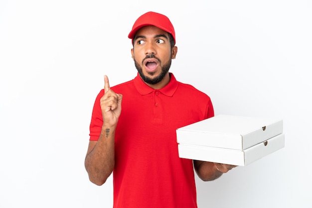 Pizzalieferant, der Pizzaschachteln aufhebt, die auf weißem Hintergrund isoliert sind, denkt an eine Idee, die mit dem Finger nach oben zeigt