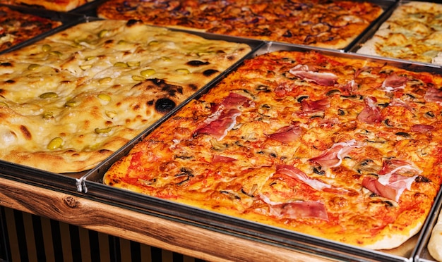 Pizzas grandes deliciosas e inusuales con champiñones y queso hechas en dos bandejas de metal