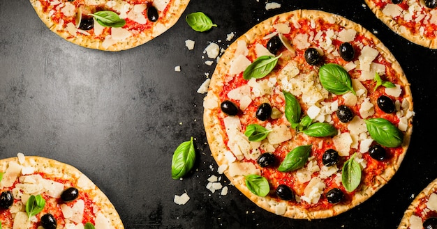 Pizzas italianas tradicionales en la mesa oscura