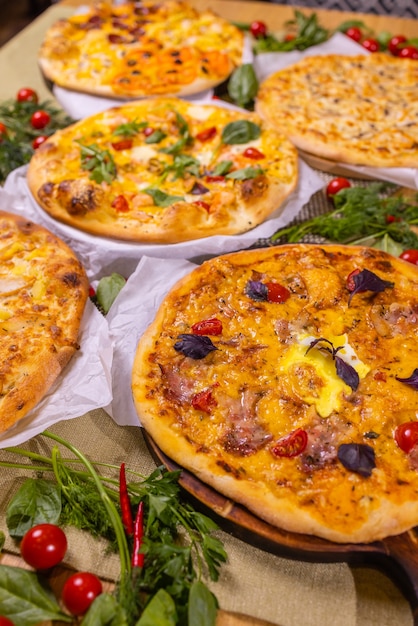 Pizzas variadas com molho. Em uma mesa de madeira.