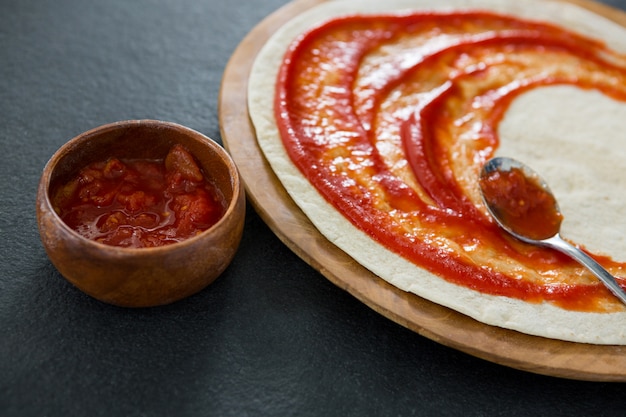 Foto pizzateig mit tomatensauce