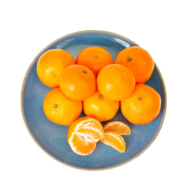 Placa azul com tangerinas laranja brilhantes, isoladas no fundo branco. Foto de estúdio