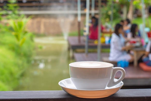 Placa branca de canecas de café com maquiagem em forma de coração nas varandas de ferro