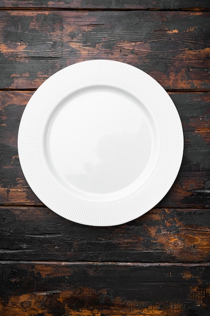 Foto placa branca vazia de cerâmica com espaço de cópia para texto ou comida com espaço de cópia para texto ou comida, vista superior plana, no fundo da velha mesa de madeira escura