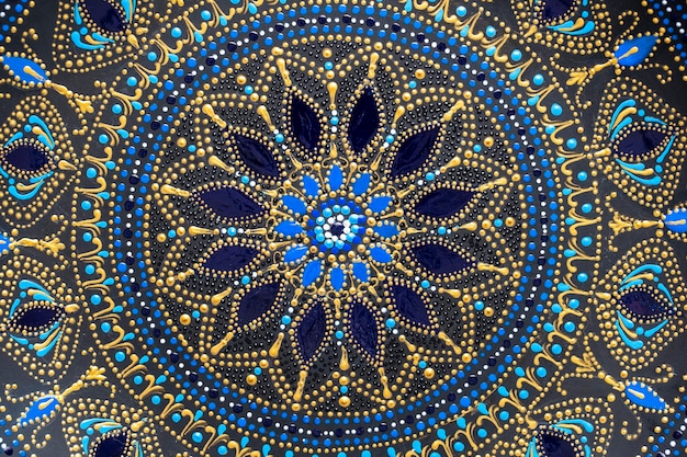Placa de cerámica decorativa con placa pintada de colores azul y dorado negro sobre pintura de puntos de fondo