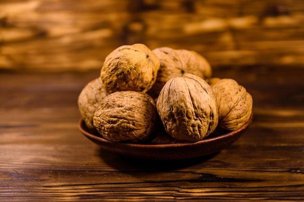 Placa de cerámica con nueces sobre mesa de madera rústica