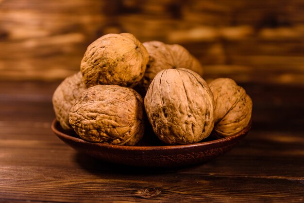 Placa de cerámica con nueces sobre mesa de madera rústica