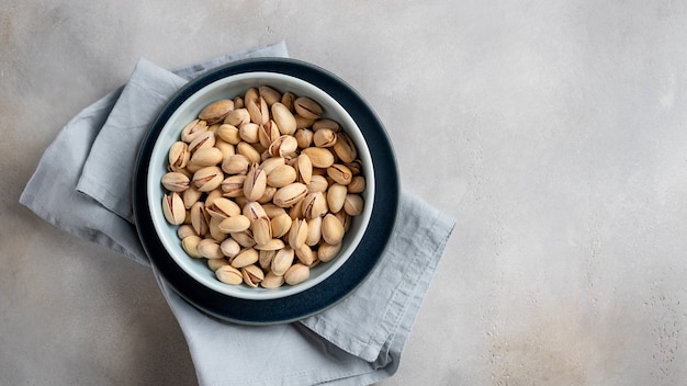 Placa de cerámica con pistachos en una pared gris. alimentación saludable