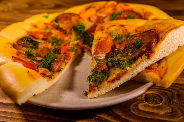 Placa de cerámica con rebanadas de pizza casera sobre mesa de madera rústica