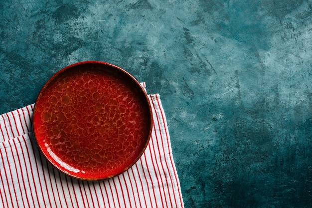 Placa de cerámica roja de fondo de cocina sobre un fondo azul.