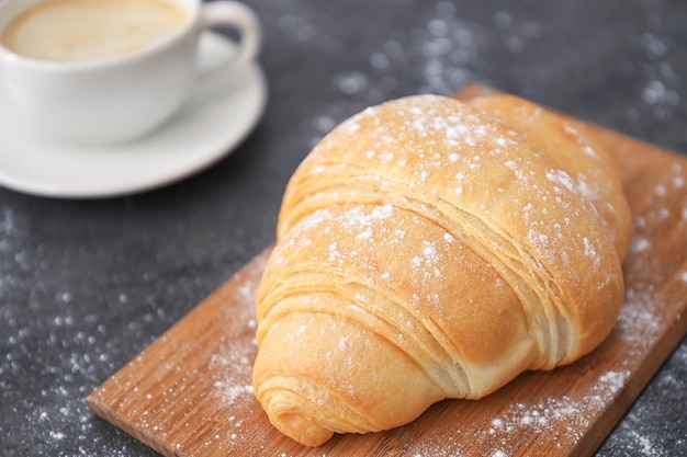 Placa com saboroso croissant na mesa fechada