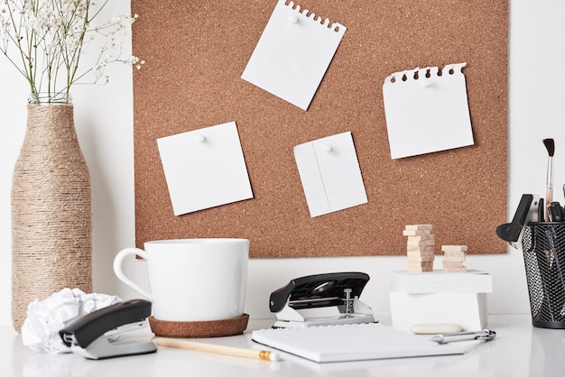 Placa de cortiça com material de escritório em fundo branco