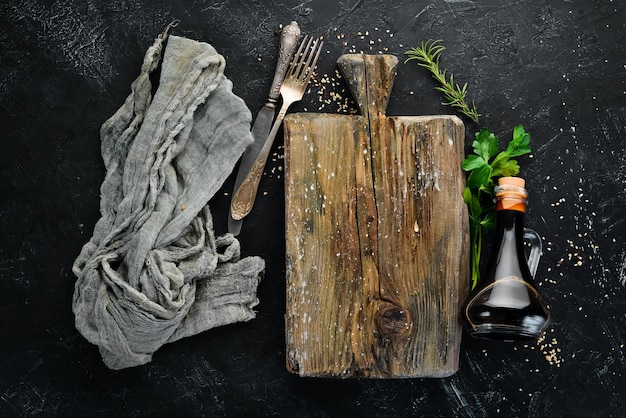 Placa de cozinha de madeira e legumes Em um fundo preto Espaço para cópia gratuita