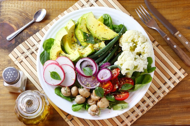 Placa de dieta cetogênica paleo e vegana abacate e salada de legumes na mesa de madeira rústica Comida vegetariana alimentação saudável vista superior