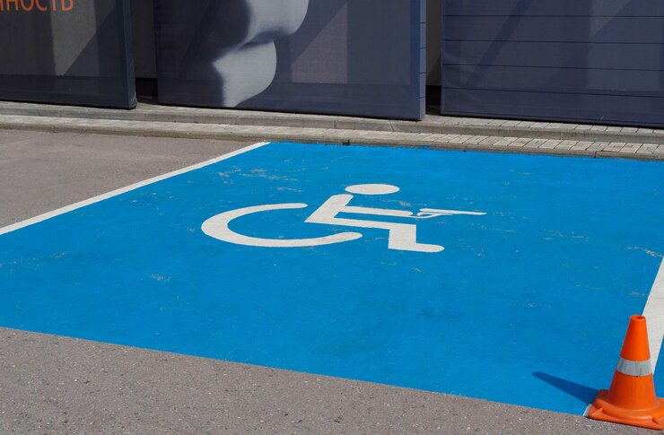 Foto placa de estacionamento no asfalto indicando local para deficientes físicos com arma de fogo