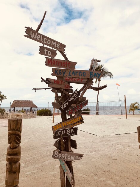 Foto placa de informação na praia contra o céu