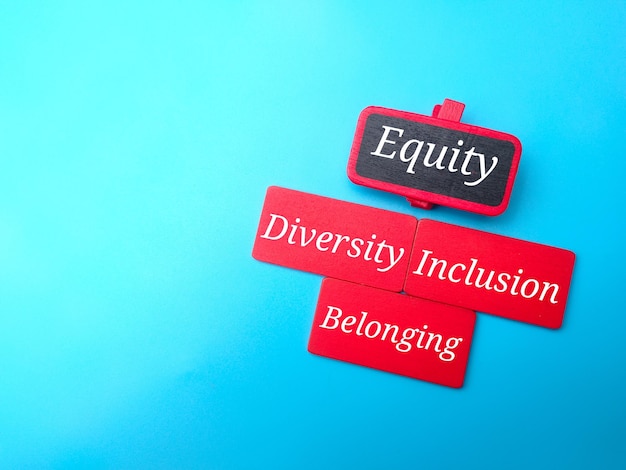 Placa de madeira colorida com texto EquityDiversityInclusionBelonging em fundo azul