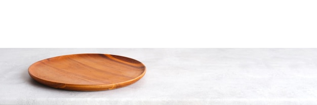 Placa de madeira redonda vazia na mesa de cimento branco e fundo de parede de cimento marrom