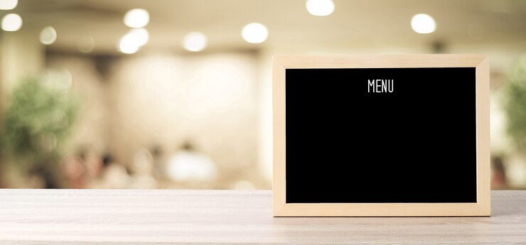 Foto placa de menu em branco sobre fundo de café borrão, conceito de comida e bebida