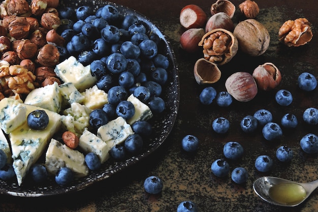 Placa de queijo com queijo azul, porcas e mirtilos. Lanche saudável. Dieta Keto