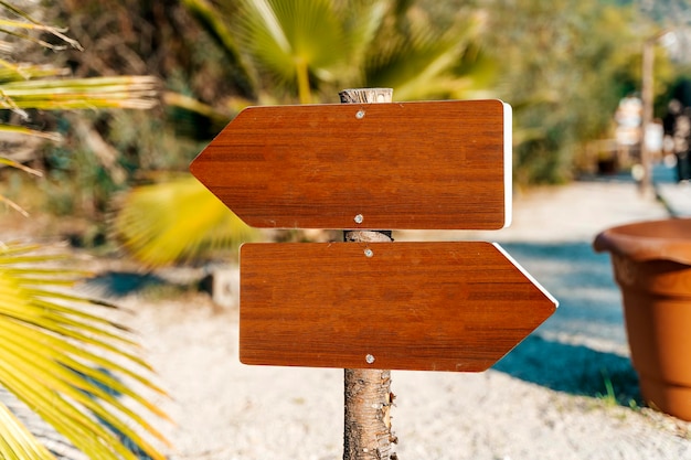 Placa de sinalização em branco na praia de verão guia de informações de madeira vazia no caminho destino c