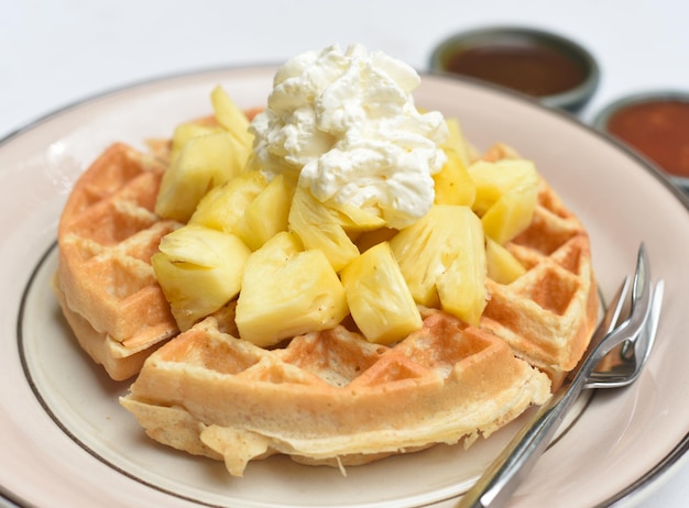 Placa de waffles da bélgica com abacaxi e resma de gelo isolado no fundo branco