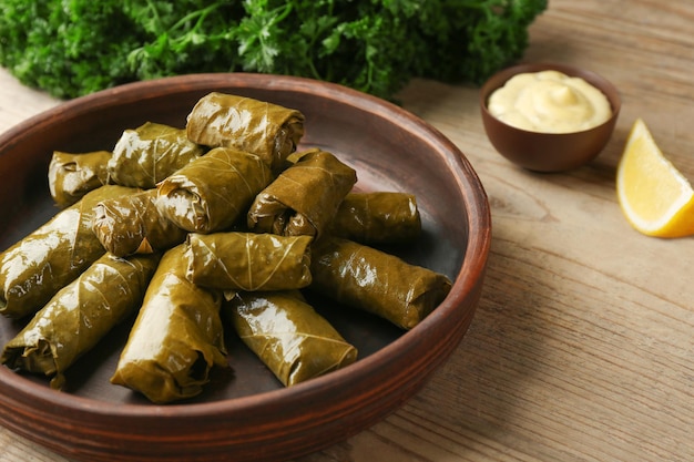 Placa con deliciosa Dolma rellena y salsa sobre mesa de madera