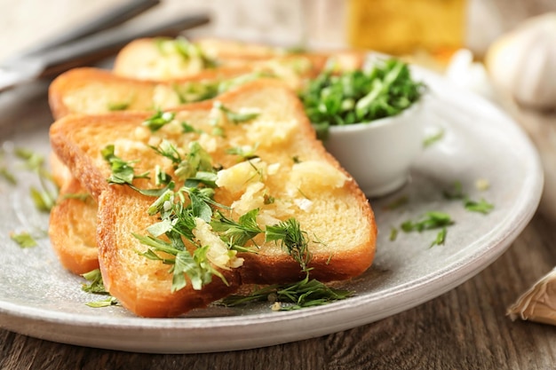 Placa con delicioso pan de ajo casero en mesa