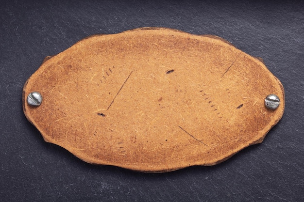 Placa de identificación de madera envejecida en el fondo de piedra pizarra