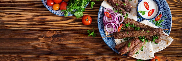 Placa de kebab de mezcla de Ramadán tradicional turco y árabe. Kebab adana, pollo, cordero y ternera sobre pan lavash con salsa.