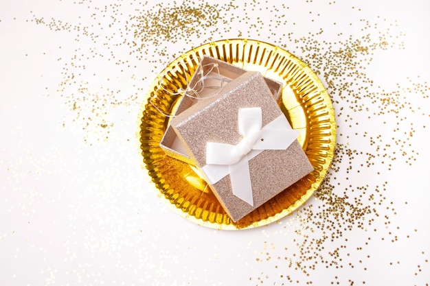 Foto placa de oro con presente de oro sobre fondo blanco. tarjeta de navidad