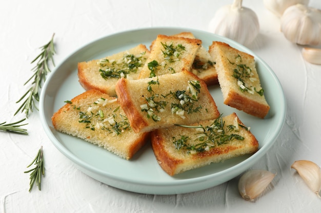 Placa con pan de ajo tostado en blanco, de cerca