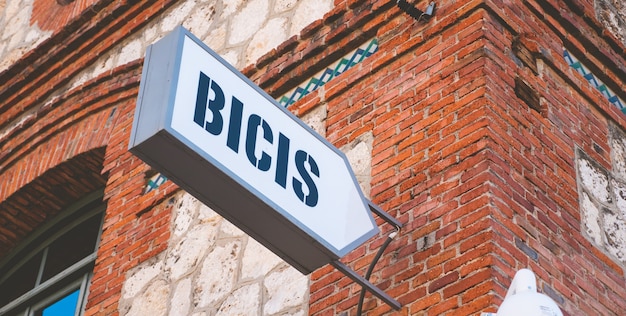 Placa pendurada na parede da rua indicando a área de estacionamento de bicicletas