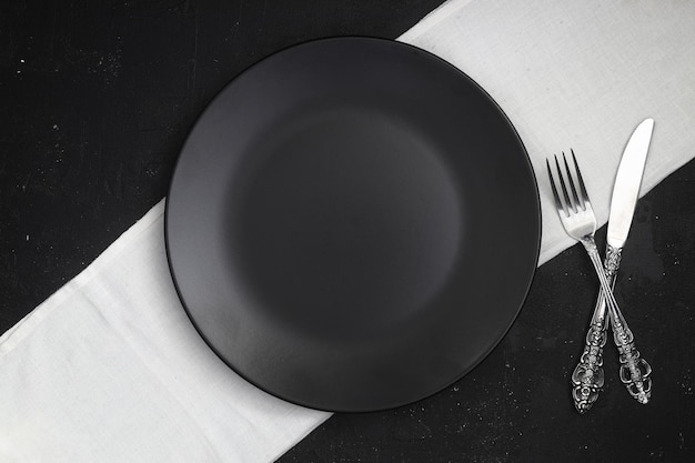 Placa de pizarra negra vacía sobre una mesa de piedra oscura Fondo de comida para la receta del menú Ajuste de la mesa