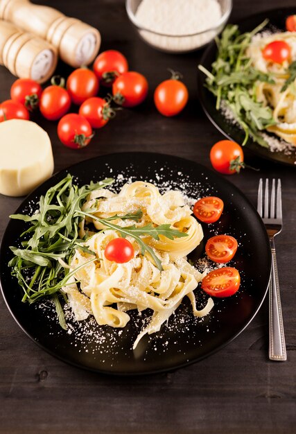 Placa preta com macarrão tagliatelle saudável na mesa de madeira