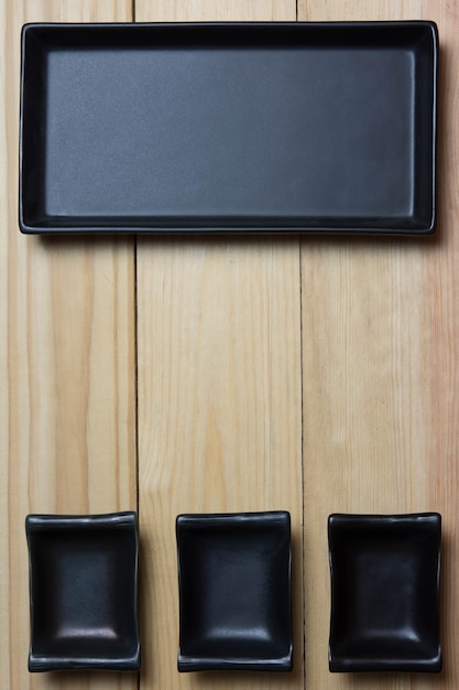 Foto placa preta rústica vazia sobre a mesa de madeira. vista aérea, com espaço de cópia.