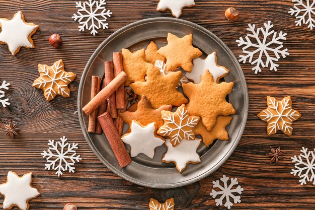 Placa con sabrosas galletas de Navidad en mesa de madera