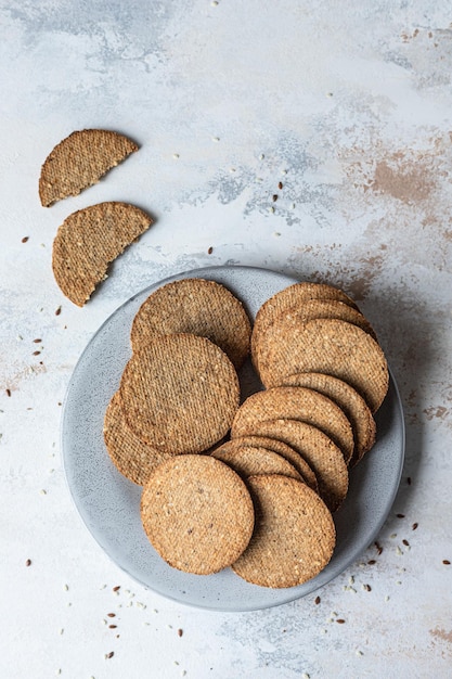 Placa con sabrosas galletas con semillas de sésamo y lino sobre fondo de piedra gris. Vista superior.