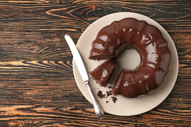 Placa con sabroso pastel de chocolate y cuchillo de mesa