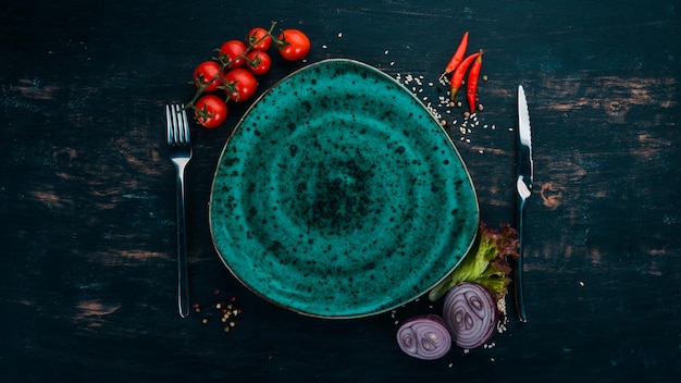 Placa verde em um fundo de madeira com legumes Em uma mesa de madeira Vista superior Copie o espaço