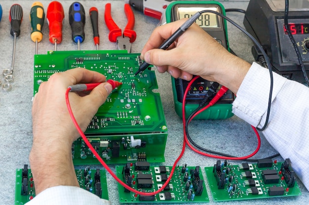 Placas eletrônicas de montagem. Verificando o dispositivo eletrônico. Trabalho na produção de eletrônicos.