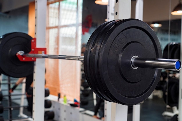 Placas de peso con mancuernas y barras de fitness en el gimnasio moderno