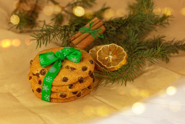 Plätzchen mit grünem Weihnachtsband, Zitrone, Zimt und Fichtenzweig auf Packpapier. festliches Gebäck und Desserts