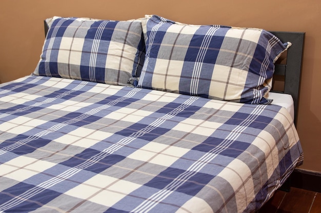 Plaid-Bett mit Kissen im Schlafzimmer-Innenraum