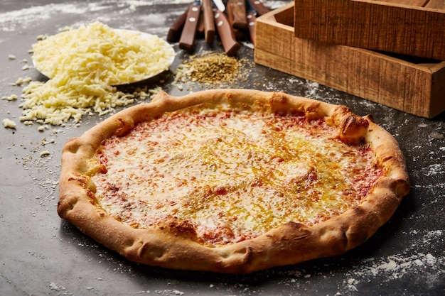 Plain Cheese Pizza isoliert auf dunklem Hintergrund mit rohem Essen Top-View der italienischen Fastfood-Vorbereitung