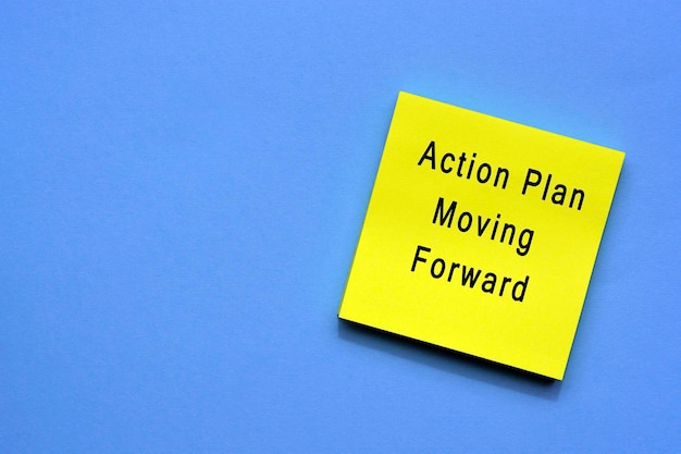 Plan de acción que avanza el texto en una nota adhesiva amarilla con fondo azul